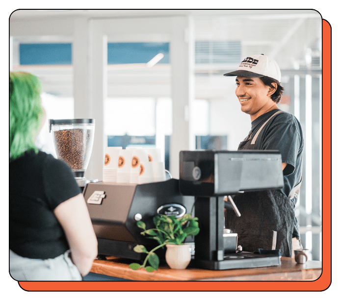 Barista serving a customer at an event with a mobile coffee cart with top quality La Marzocco coffee equipment and decor.