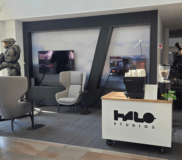 Halo Studios reception area with chairs, screens, and a branded mobile coffee cart