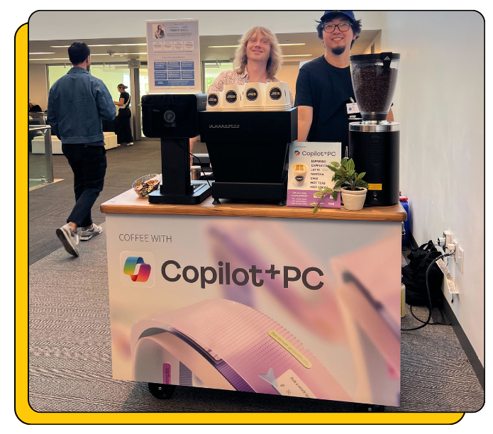 Custom Coffee Cart Rental, with mobile coffee machines and promotional materials for Copilot+PC in an indoor setting.