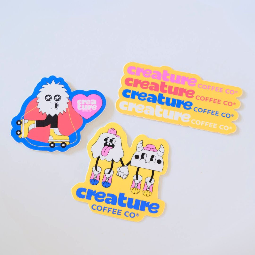 Set of stickers with cartoon characters and 'creature coffee co' branding on a light blue background. GIft from Specialty Coffee Roaster.